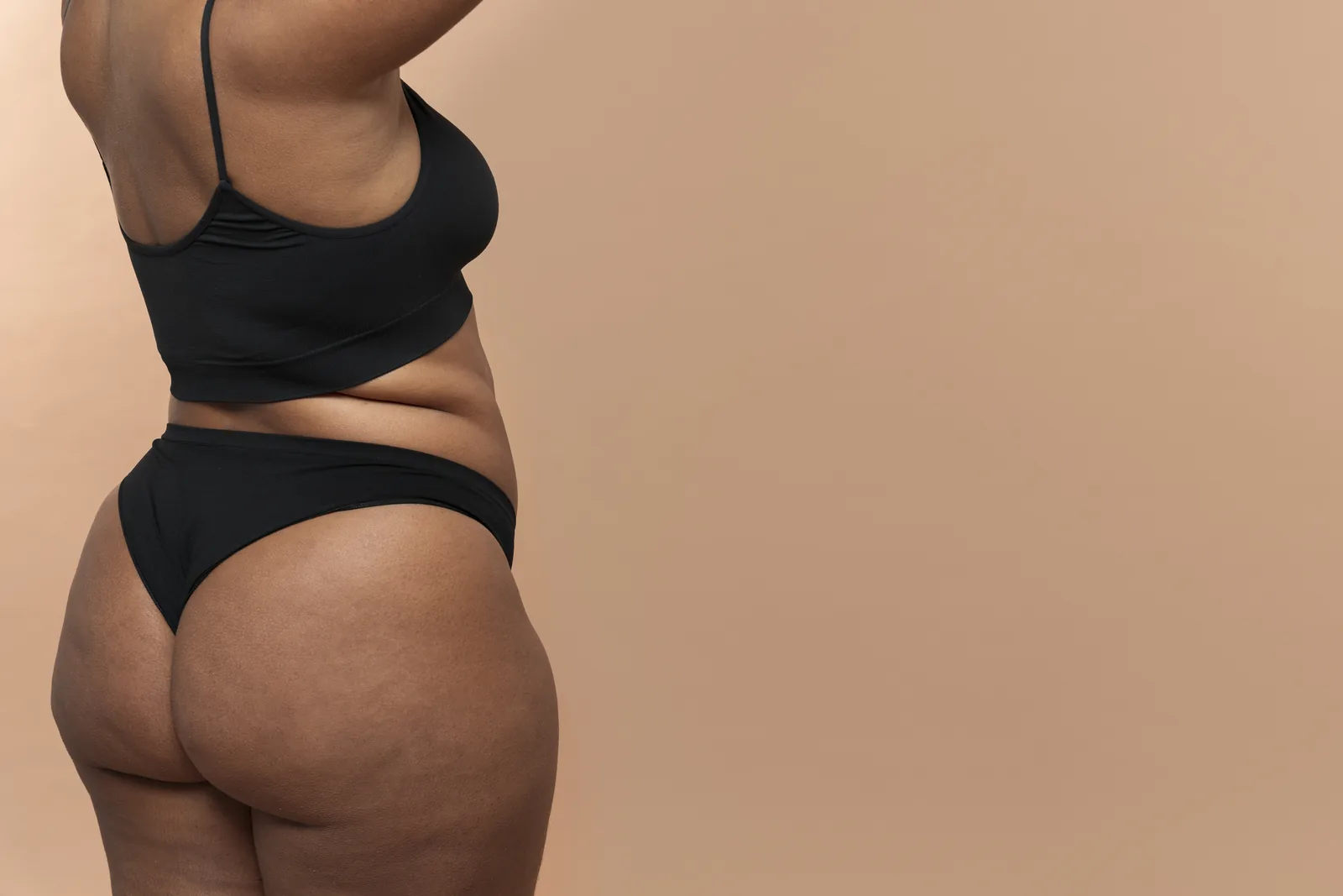 Perfil de mulher em lingerie verde, contorno natural do quadril e dos glúteos