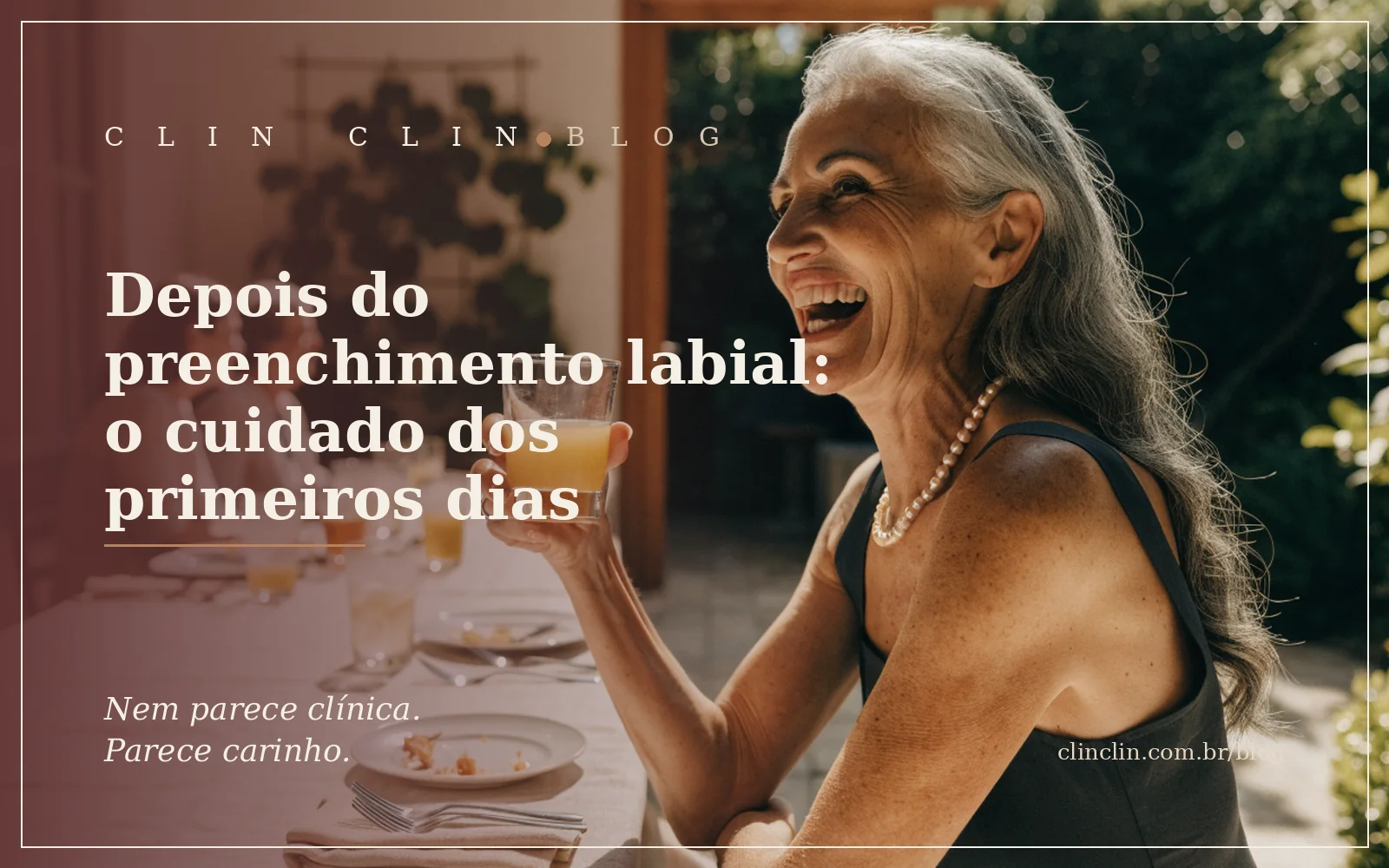 Mulher de uns sessenta anos, cabelo grisalho longo e ondulado solto, rindo de verdade e erguendo um copo de suco num brinde, à mesa de um almoço de domingo numa varanda ensolarada com amigas ao fundo.