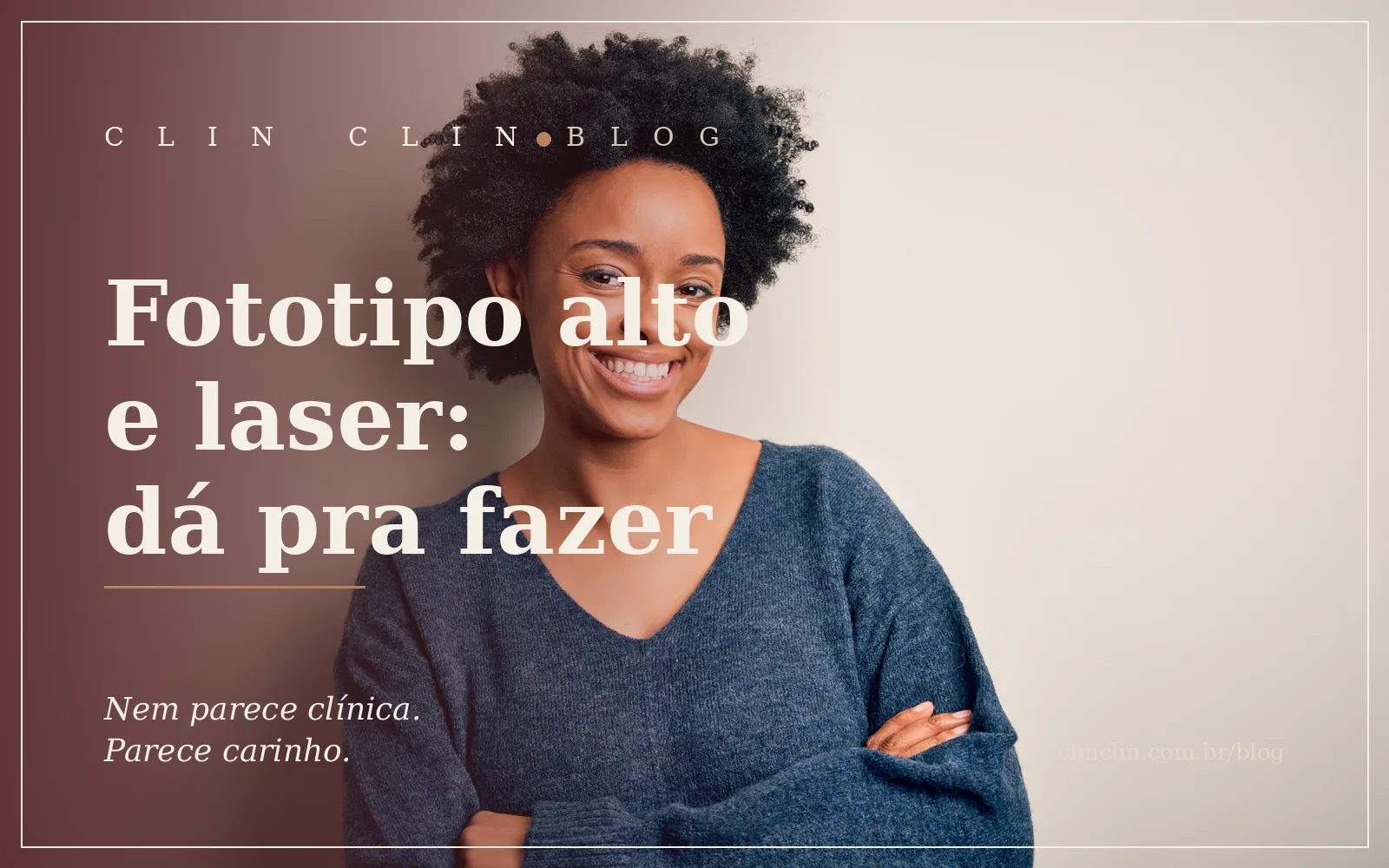 Mulher negra de suéter azul, braços cruzados, sorrindo, em luz natural suave