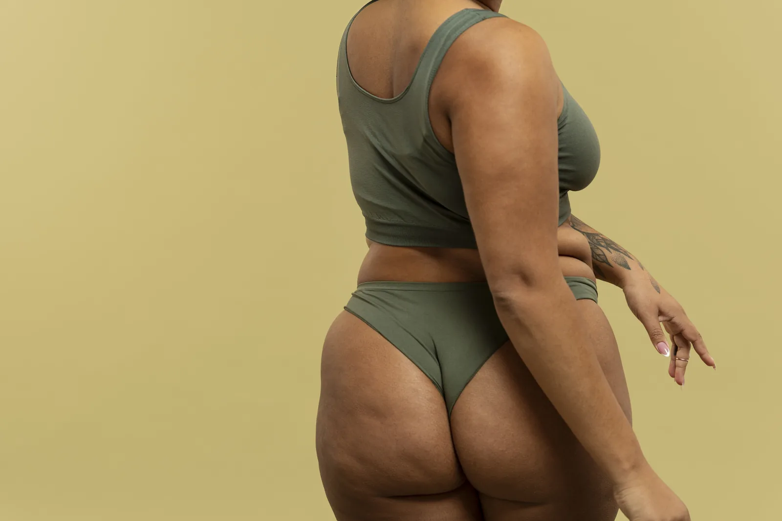 Perfil de mulher em lingerie preta, corpo real, pele com textura natural