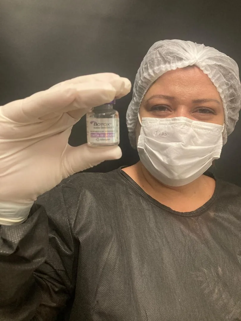Dra. Marisa Kelly paramentada segurando frasco de toxina botulínica na Clin Clin, Belo Horizonte